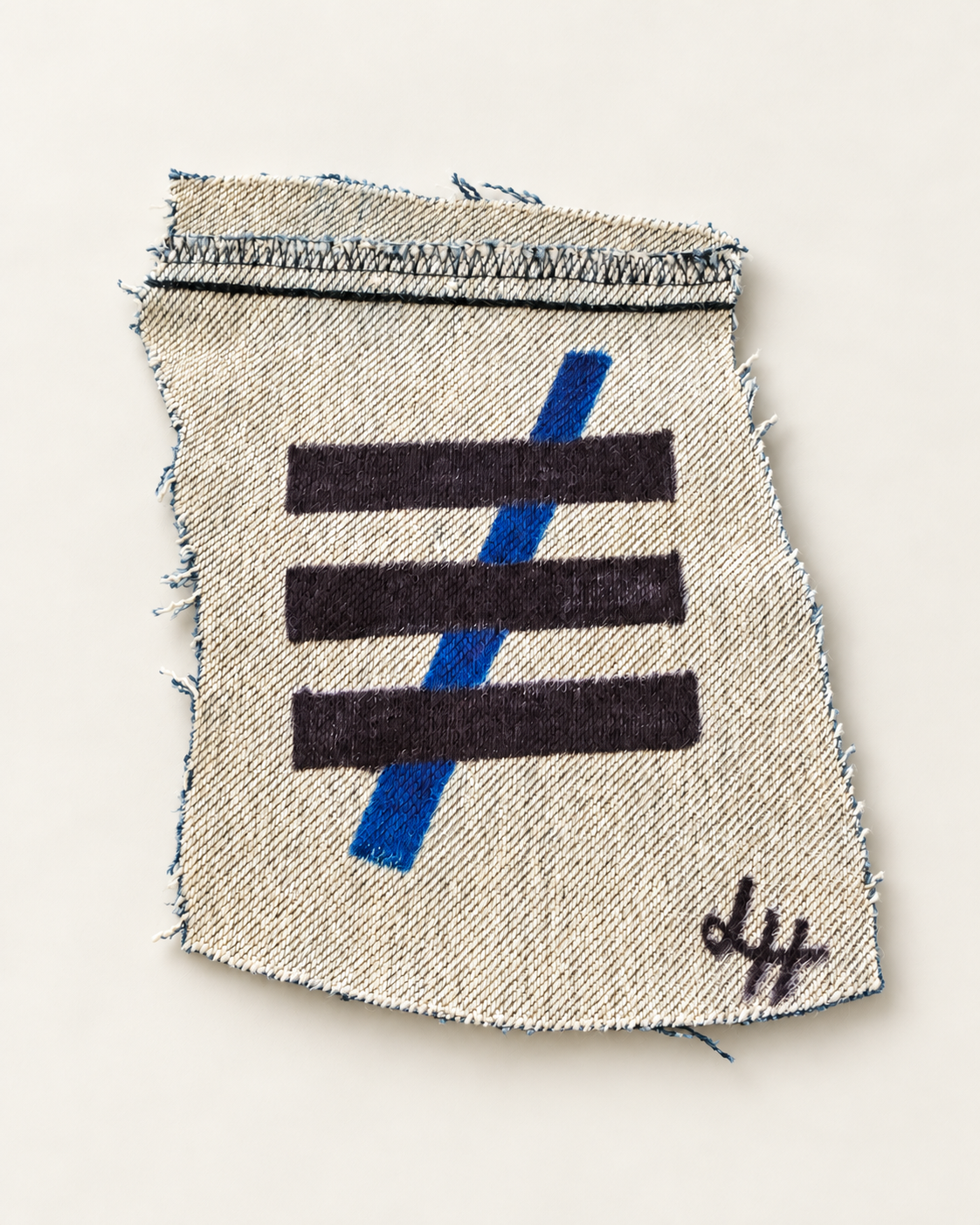 Three black bars crossed by a blue diagonal on a frayed cream textile, with a visible artist signature.